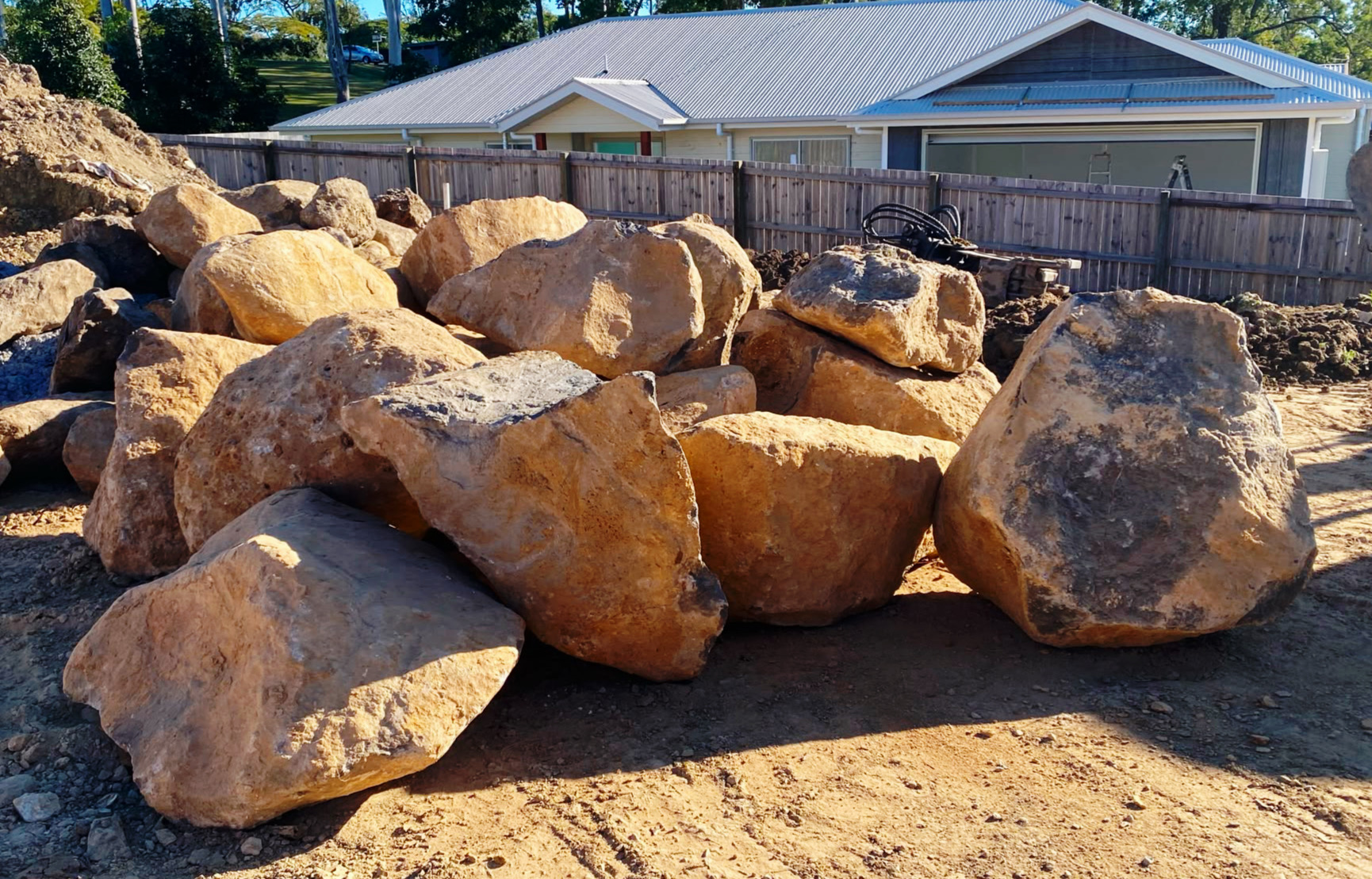 Basalt bushrock boulders stockpiled on a job site