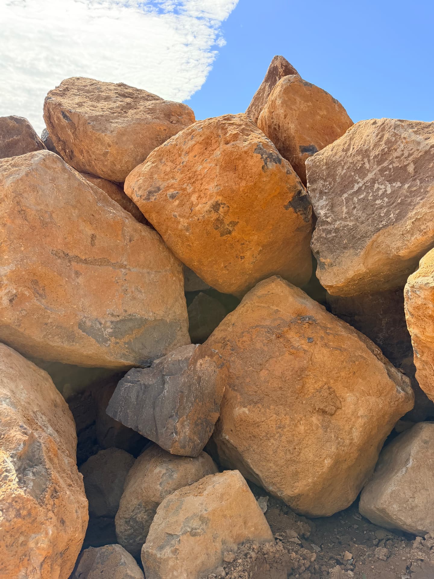 Large blocky rocks stacked in the sun, ready to load